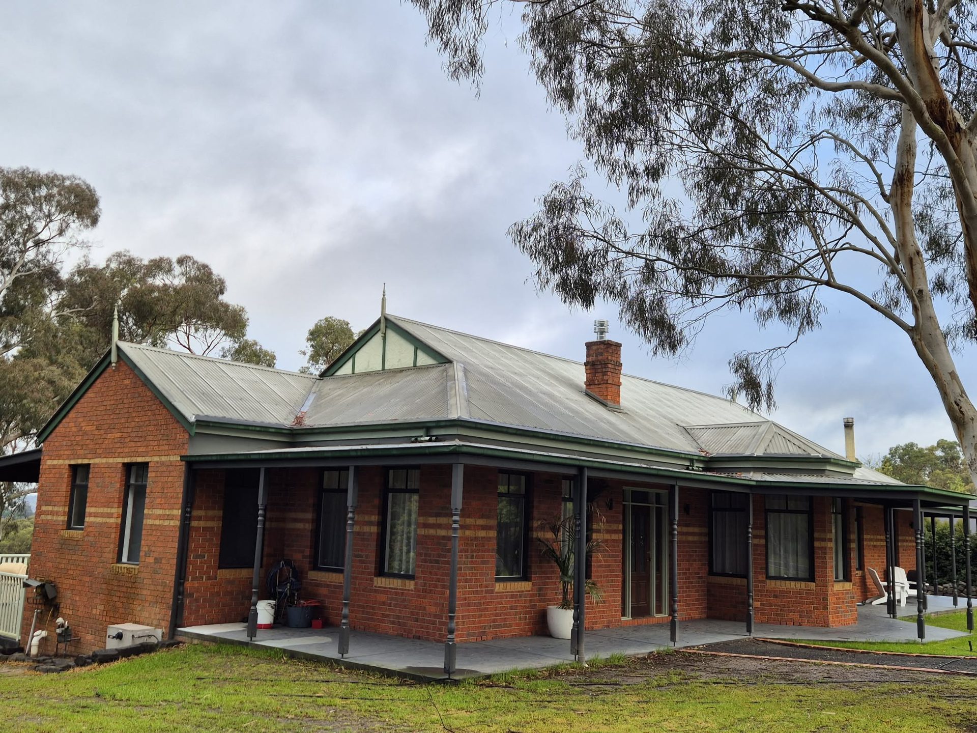 Federation red brick home with faded galvanised iron — before