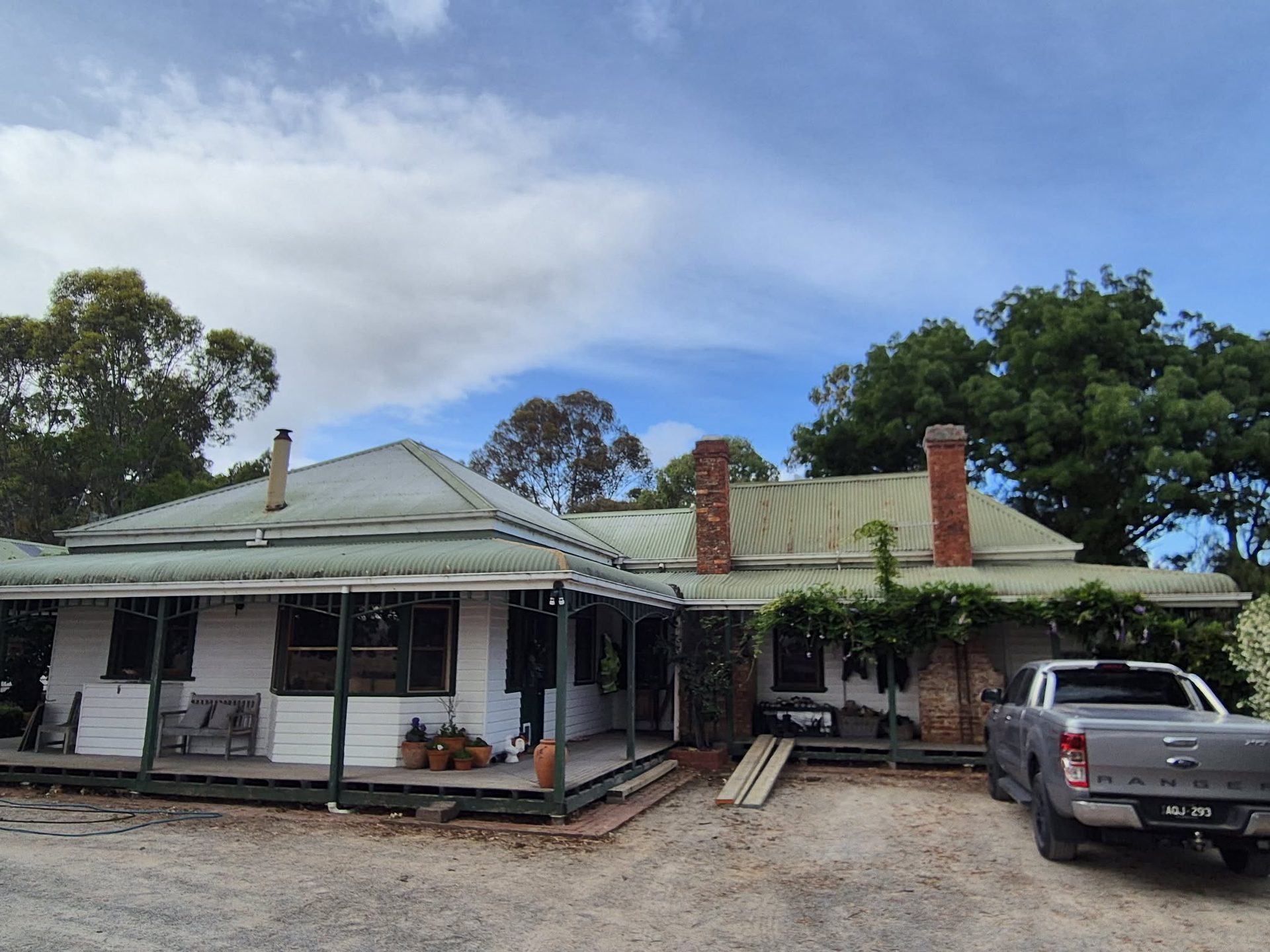 Heritage country home with tired sage-green iron roof — before restoration
