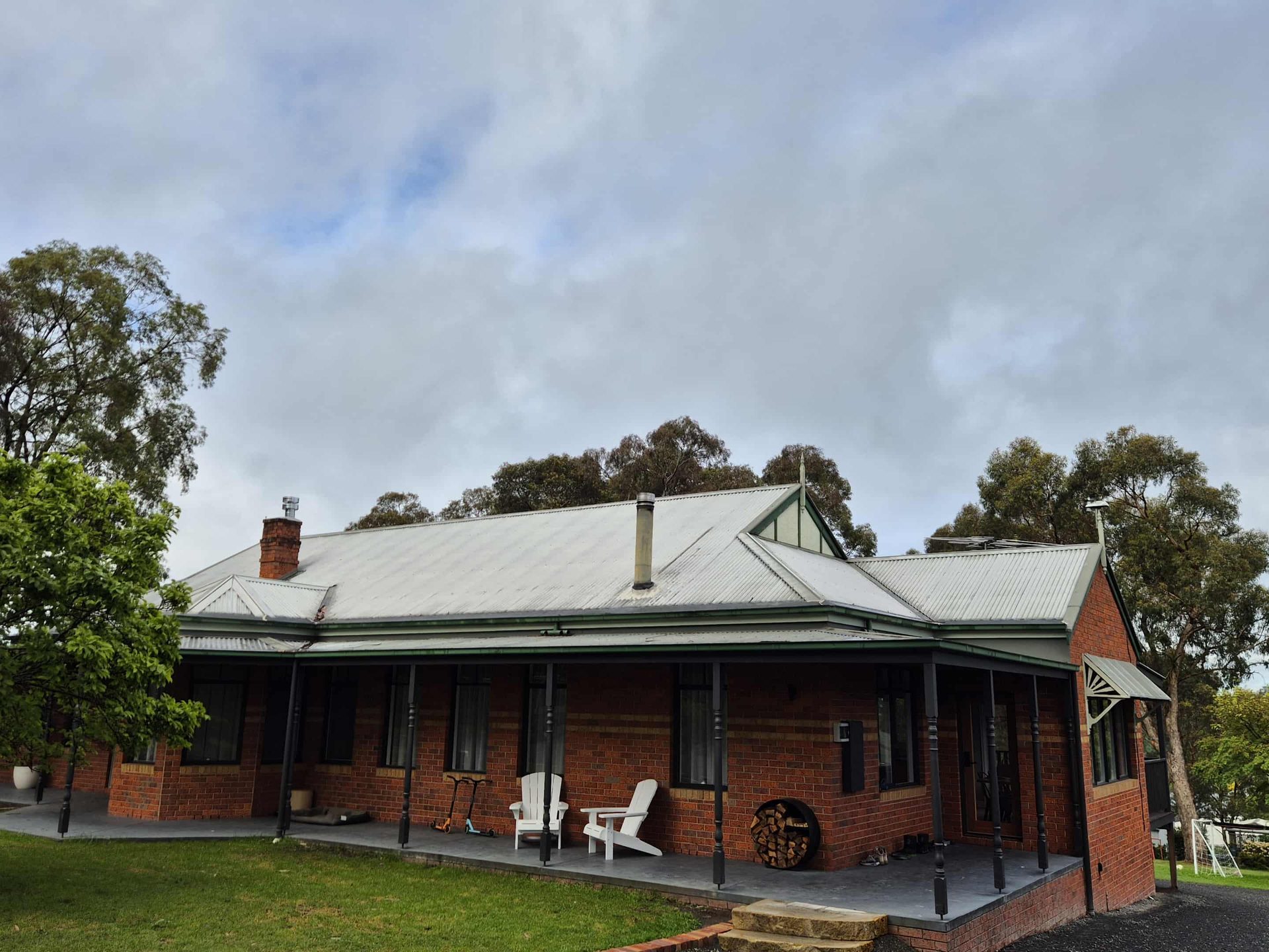 Red brick country home with faded iron roof — before restoration