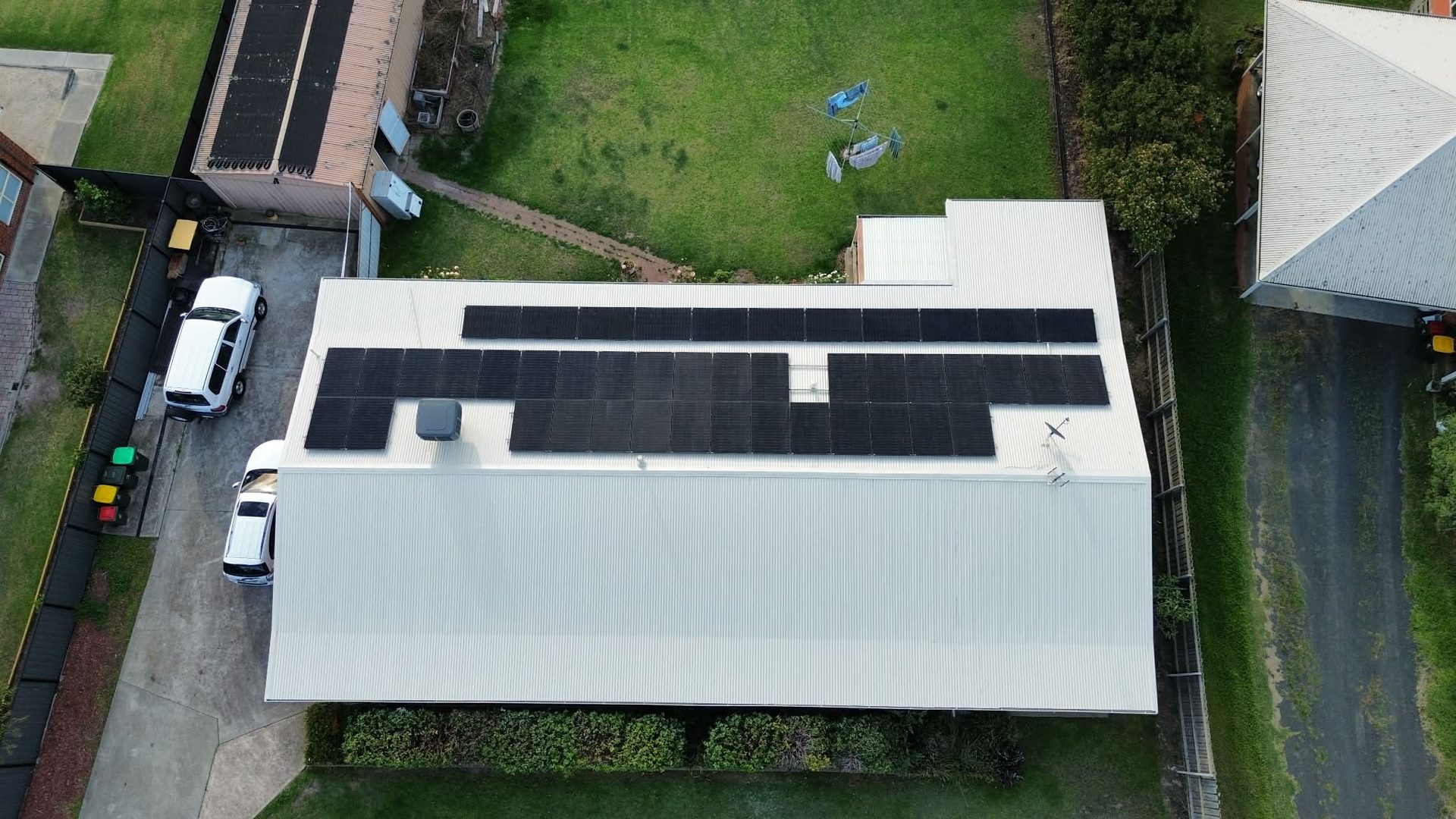 Aerial view of same home with cleaned, refreshed white metal roof